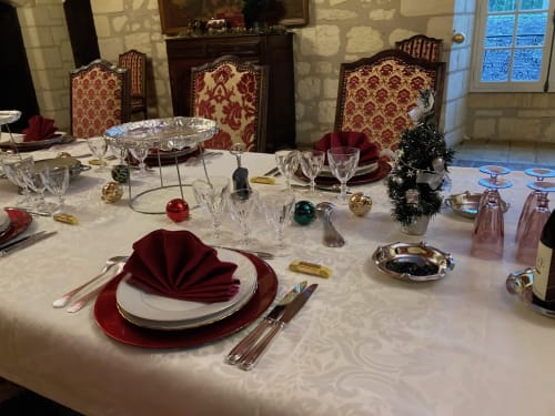 Table de salle à manger élégante au Château de Ré avec serviettes rouges, verres en cristal et décorations de fête au Petit