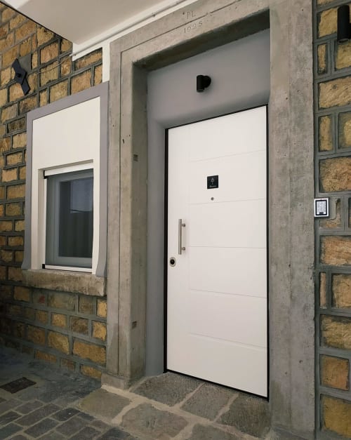 Moderna porta d'ingresso bianca della struttura B&B La Pigna a Filiano con facciata in laterizio e finestra