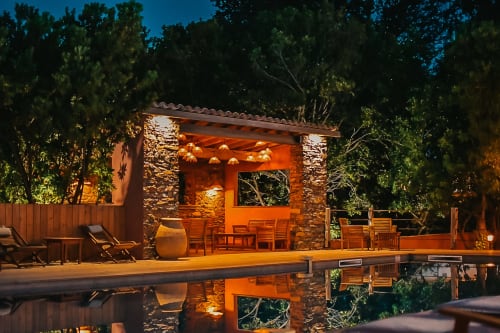 Terrasse en pierre du Maquis Plage au crépuscule avec salon de piscine illuminé à Poggio-Mezzana