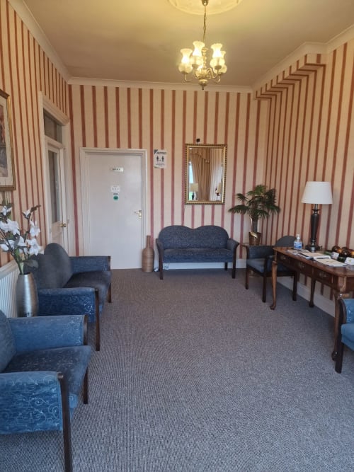 Elegant lounge at The Sands Hotel in Paignton with striped wallpaper, blue upholstered seating, wooden furniture and