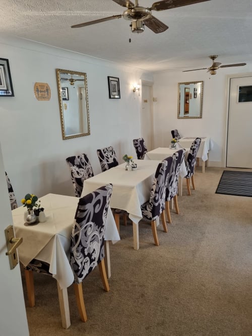 Dining room at The Sands Hotel Paignton with white-draped tables and patterned chairs