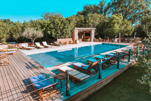 Piscine luxueuse de la villa Le Maquis Plage à Poggio-Mezzana, avec bassin aux eaux cristallines et transats en bois