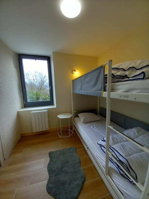 Chambre lumineuse avec lit superposé à La Maison De Fleurat à Domeyrot, fenêtre donnant sur le jardin, parquet
