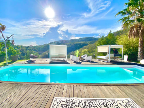 Terrace de luxe au bord de la piscine de Villa Colina à Mandelieu avec eaux turquoise, transats, cabanas et vue sur les montagnes