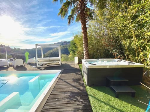 Terrasse luxueuse de Villa Colina avec piscine, bain à remous, transats, palmiers et vue panoramique à Mandelieu-la-Napoule