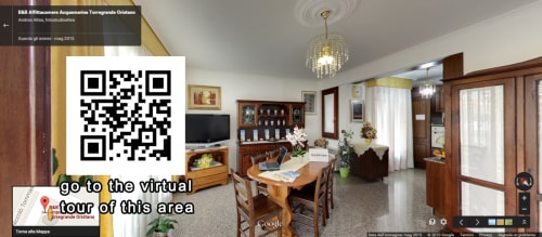 Réception de la Double Moon Room à l'Affittacamere Al Mare, Torre Grande Oristano, avec table à manger, télévision et mobilier en bois