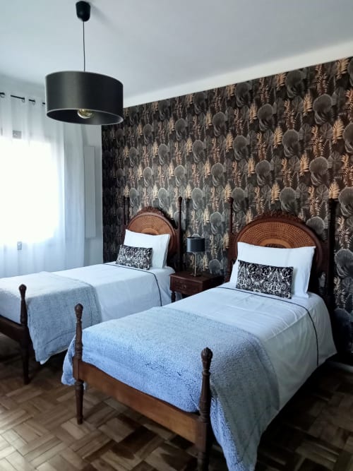 Twin bedroom at Patio Da Villa guesthouse in Coruche with two single beds, rattan headboards, and botanical wallpaper