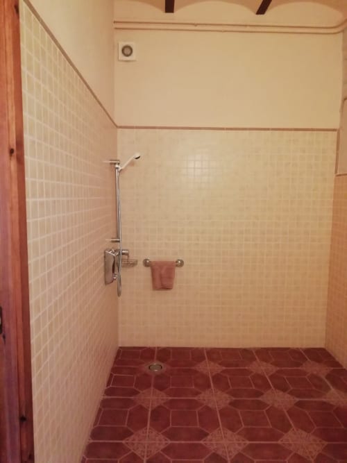 Habitación Rossinyol|Sant Martí de Centelles-Alcoba situada en la planta baja y con vistas a la soleada era de la masía, pensada y adaptada para personas con discapacidad o con movilidad reducida. Su cama es doble y tiene incrustaciones de marquetería, mientras que el armario se ofrece más bajo, pensado para servir una mayor comodidad de acceso.