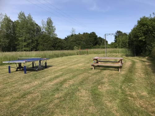 Espace de loisirs extérieur aux Gîtes De L'odet à Clohars-Fouesnant avec table de ping-pong, tables de pique-nique et équipements sportifs