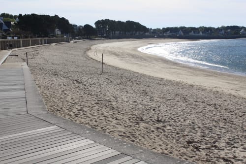 Plage de sable aux Gîtes De L'odet à Clohars-Fouesnant avec passerelle en bois et vue sur le village côtier