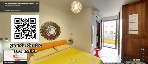 Chambre double lumineuse avec literie jaune, tête de lit orange et vue sur le balcon à l'hôtel Al Mare Oristano