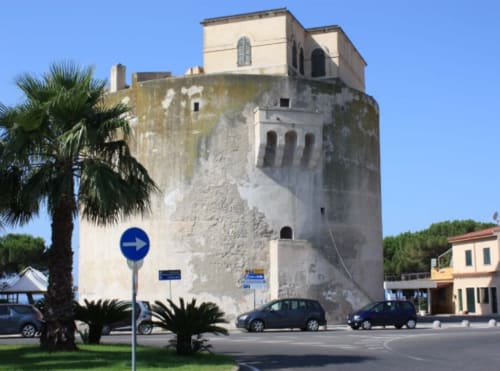 Torre Grande à Oristano : édifice historique avec palmiers et architecture méditerranéenne