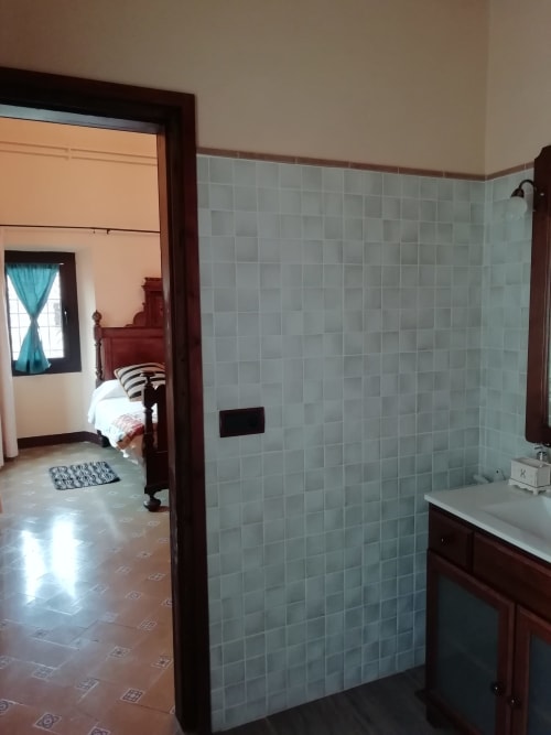 Habitación Ou de Reig|Sant Martí de Centelles -Aposento situado en la planta noble de la masía, con vistas al Turó de l’Antiga y a la antigua hacienda; a la que se accede por un amplio y elegante salón, núcleo de acceso en las grandes cámaras de la masía. Esta sala conserva gentiles mesas, sillas y butacas, para poder leer, estar en familia haciendo sobremesa o sencillamente descansar.