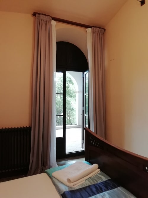 Habitación Fredolic|Sant Martí de Centelles-Aposento particularmente espacioso, cubierto con vuelta de arco redondo, cálido y con mucha luz natural, situado en planta noble de la masía; con vistas a la antigua era, a los jardines de a mediodía y a la piscina de agua salada, dispuesta para los huéspedes en estaciones templadas.