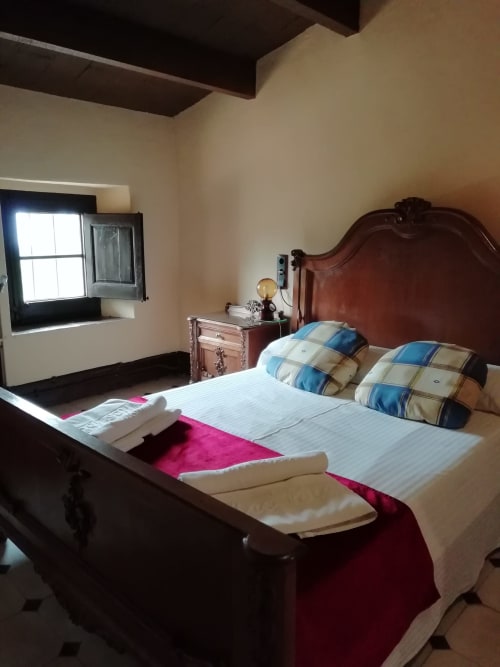 Habitación Moixernó|Sant Martí de Centelles -Está equipada con un grande y solemne armario de tocador incorporado y ofrece un alojamiento versátil, puesto que dispone de una cama doble y la alcoba se comunica por una puerta interior con una habitación doble o triple, denominada Gírgola, permitiendo el alojamiento de una hasta cinco personas.