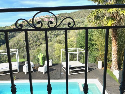 Terrasse de la Villa Colina avec balustrade ornementale surplombant la piscine, les palmiers et le paysage de Mandelieu-la-Napoule