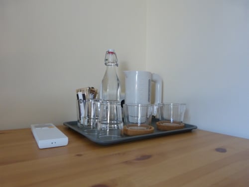 Coffee and beverage station in Villa Thébaïde Lavande room with glasses, bottle, and amenities