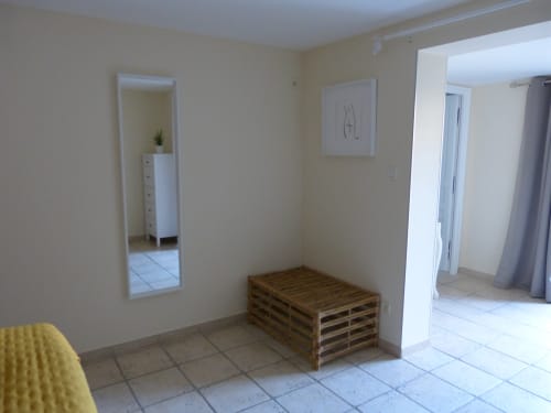 Spacious Lavande room at Villa Thébaïde BnB with wooden pallet furniture, mirror, and tile flooring
