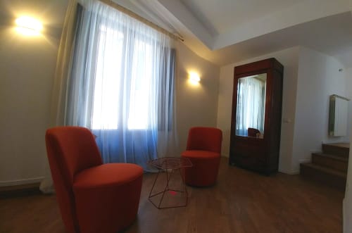 Elegant suite at Stella CasaBono in Sulmona featuring red seating chairs, modern furnishings, and natural light from terrace