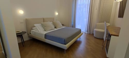 Modern junior suite bedroom at Stella CasaBono hotel in Sulmona with city view balcony, contemporary bed, and elegant
