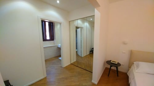 Stella CasaBono junior suite in Sulmona featuring mirrored wardrobe, wooden floors, and modern furnishings with city view