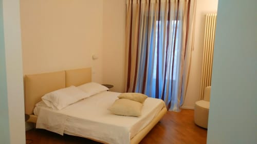 Bright junior suite bedroom at Stella CasaBono hotel in Sulmona with beige bedding, large windows with curtains overlooking