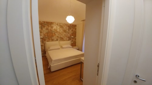 Suite De Luxe bedroom at Stella CasaBono hotel in Sulmona with queen bed and warm interior décor