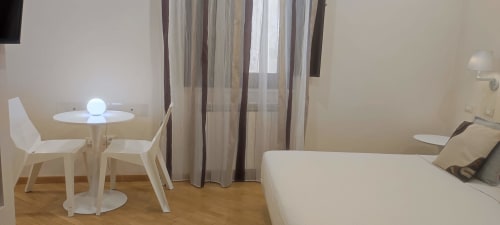 Junior Suite De Luxe at Stella CasaBono hotel in Sulmona with white furniture, bed, dining area and striped curtains