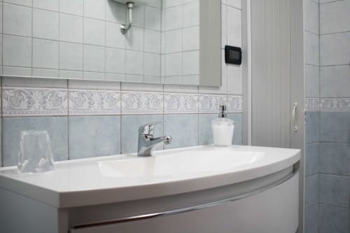 Modern bathroom sink with elegant tilework at Affittacamere Al Mare in Torre Grande Oristano