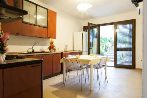 Cucina e sala da pranzo moderne presso Affittacamere Al Mare a Torre Grande Oristano con mobili in legno, tavolo per due