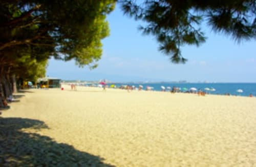 Spiaggia sabbiosa a Torre Grande con riva alberata, acqua turchese e bagnanti vicino ad Affittacamere Al Mare