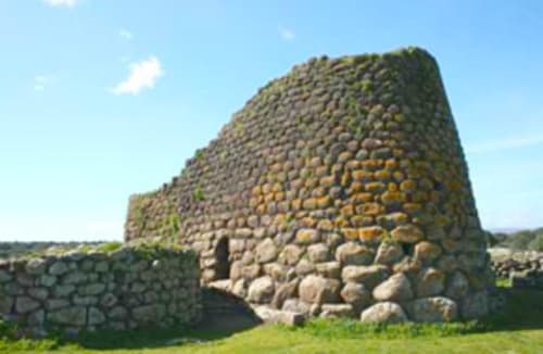 Ruinas de la antigua torre en Torre Grande, Oristano, Italia, con muros cubiertos de musgo y paisaje verde