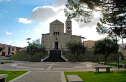 Steinkirche mit Glockenturm in Torre Grande, Oristano, umgeben von grünem Platz und Bäumen