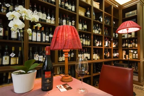Stella CasaBono wine bar tasting room in Sulmona with red lamp, wine bottles, and orchids