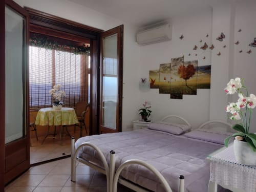 Camera familiare con letti gemelli, aria condizionata e balcone affacciato sul giardino presso Affittacamere Al Mare a Torre Grande, Oristano