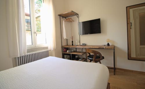 Piccola camera doppia a Porta Tosa Milano con letto, scrivania, TV, armadio e vista sul giardino