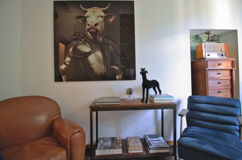 Lounge Porta Tosa Milano con poltrona in pelle, ritratto di toro, scrivania in legno e cassettone vintage