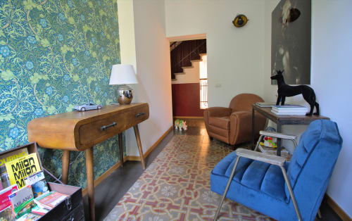 Lobby Porta Tosa Milano con arredi mid-century, carta da parati decorativa, scrivania in legno, sedie blu