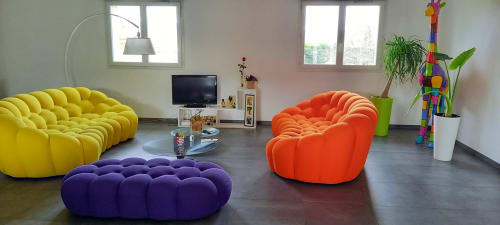 Salon moderne et coloré chez Chez Anne Marie B&B avec fauteuils bulles jaune, violet et orange, écran plat et vert