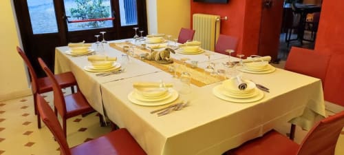 Elegantly set dining table with yellow linens at Stella CasaBono hotel in Sulmona, ready for guests