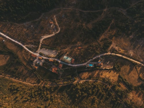 Moinhos d’Antoninha do alto: um refúgio de tranquilidade onde a natureza e a arquitetura tradicional se fundem, com piscina, caminhos de terra e a serenidade da Serra de Leomil.
