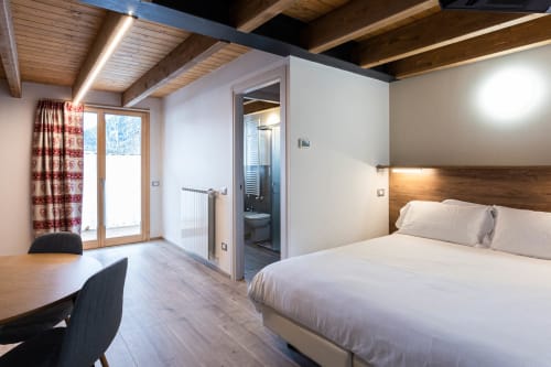 Camera moderna presso la Residence Villa Brioschi ad Aprica con letto queen, scrivania, bagno ensuite e vista alpina