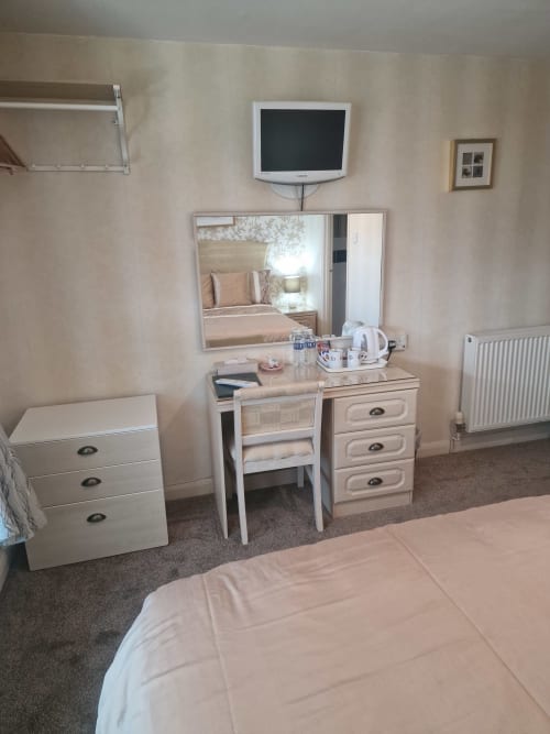Double bedroom at The Sands Hotel, Paignton with dressing table, TV, and sea view mirror reflection