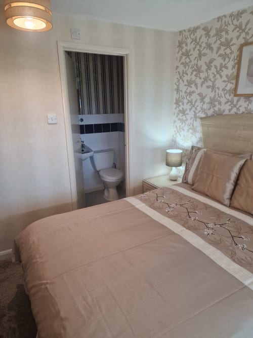 Double bedroom at The Sands Hotel, Paignton with en-suite bathroom, sea view wallpaper and cream bedding