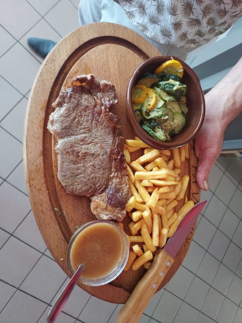 Steak grillé avec frites et légumes rôtis sur planche en bois au Gîte Le Comtois à Saône, France