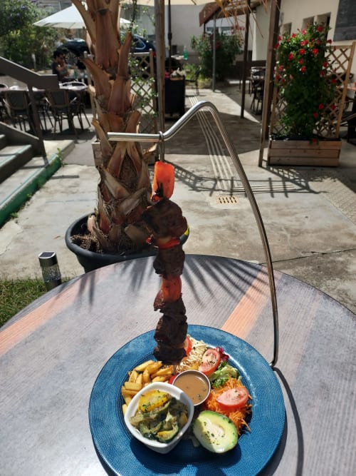 Brochette de viande grillée avec frites et légumes à la terrasse du Comtois à Saône, France