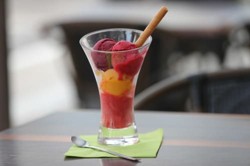 Boisson aux fruits multicolore et stratifiée avec cuillères rouges et paille en bois au gîte Le Comtois à Saône, France