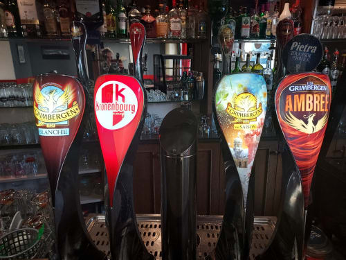 Pompes à bière au bar Le Comtois, région Saône en France, présentant les marques Grimbergen et Kronenbourg