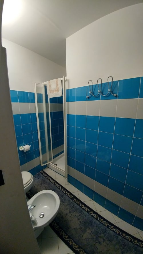 Modernes Badezimmer im Hotel Stella CasaBono in Sulmona mit blau-weißen Fliesen, Dusche und Waschbecken