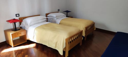 Zwei Holzbetten mit weißen Kissen und gelben Decken im Hotel Stella CasaBono in Sulmona